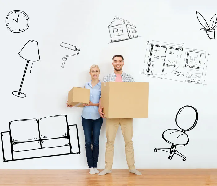 A couple stands smiling with boxes in hand against a backdrop of illustrated furniture and household items, suggesting a new home.